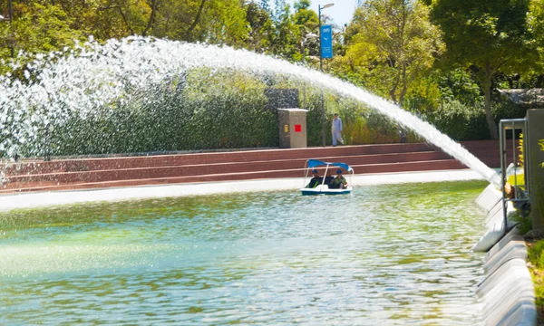 Laguna pacífica dentro del parque interior de la ciudad, arco de agua disparando a través del canal en un hermoso día soleado — Foto de Stock