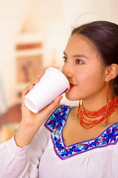 Bonita joven vestida con blusa andina tradicional, de pie bebiendo café de taza blanca — Foto de Stock