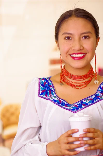 Foto de la cabeza bonita mujer joven con blusa andina tradicional, sosteniendo taza de café blanco, frente a la cámara, sonrisa hermosa — Foto de Stock