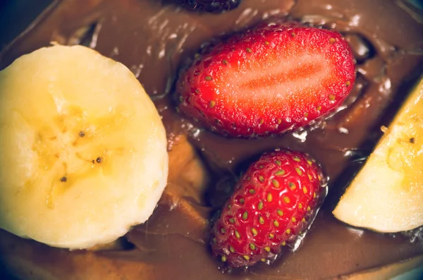 Banana and strawberry on chocolate sauce from above angle — Stock Photo, Image