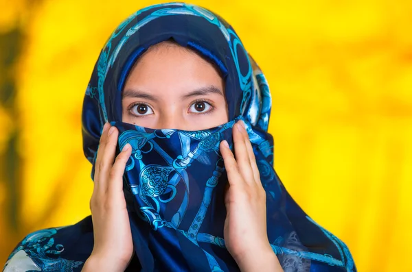 Piękna młoda muzułmańska kobieta ubrana w niebieskie, kolorowe hidżab, stoi aparat pozowanie tajemniczo, jesienny Las tło — Zdjęcie stockowe