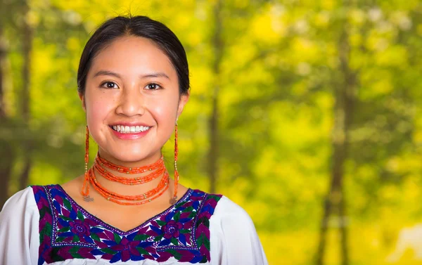 Красивая молодая женщина в традиционной андской блузке с красным ожерельем, позируя для камеры трогательное лицо с помощью рук, улыбаясь счастливо, зеленый фон леса — стоковое фото