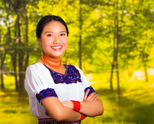 Mooie jonge vrouw die het dragen van traditionele Andes blouse met ketting, permanent armen poseren voor de camera, gekruist glimlachend gelukkig, groene bos achtergrond — Stockfoto