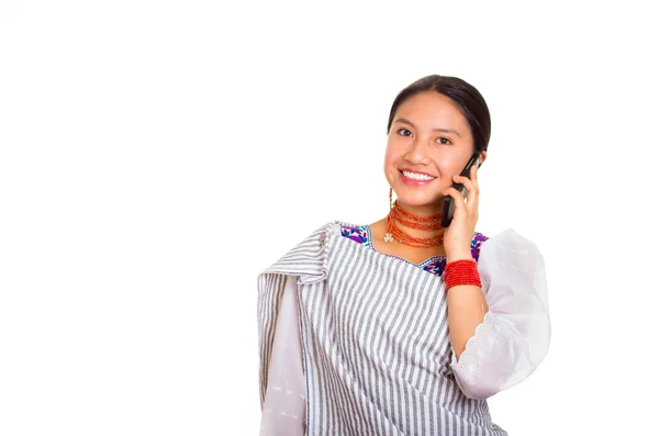 Cabeza hermosa mujer joven con chal andino tradicional y collar rojo, hablando en el teléfono móvil sonriendo felizmente, fondo de estudio blanco — Foto de Stock