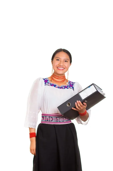 Красивая молодая женщина стоит в традиционной андской блузке и красном ожерелье, держа черное кольцо папку, улыбаясь счастливо, белый студийный фон — стоковое фото