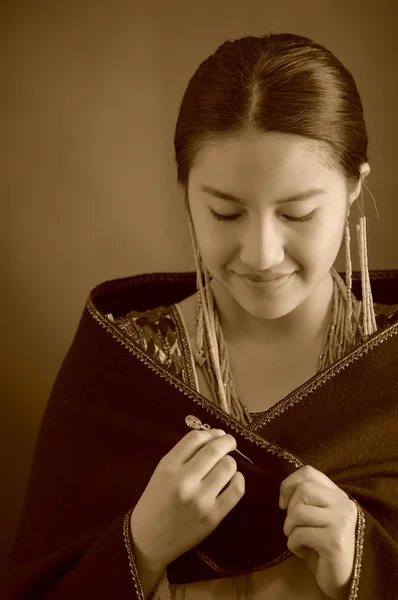 Красивая латиноамериканская модель в традиционной одежде, темное пончо сверху, улыбающаяся поза для камеры, скрипучие пальцы, студийный фон, черно-белое издание — стоковое фото