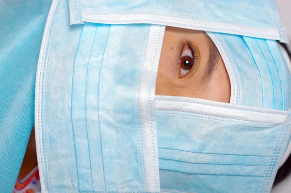 Closeup eye of woman peeking out from total facial cover, preparing for cosmetic surgery concept, doctor using red measure tool — Stock Photo, Image