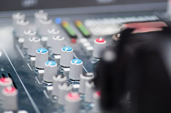 Closeup mixing console with headphones on top, faders and knobs background, artistic studio equipment concept — Stock Photo, Image