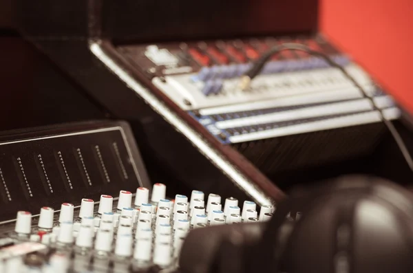 Closeup mixing console with headphones on top, faders and knobs background, artistic studio equipment concept — Stock Photo, Image