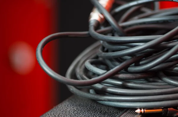 Closeup standard black audio cables rolled into bundle, studio equipment concept — Stock Photo, Image