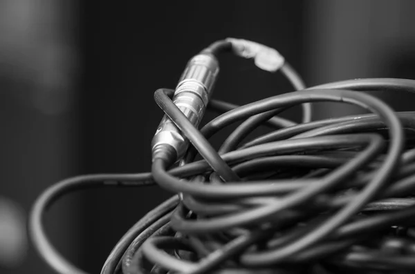 Closeup standard black audio cables rolled into bundle, studio equipment concept — Stock Photo, Image