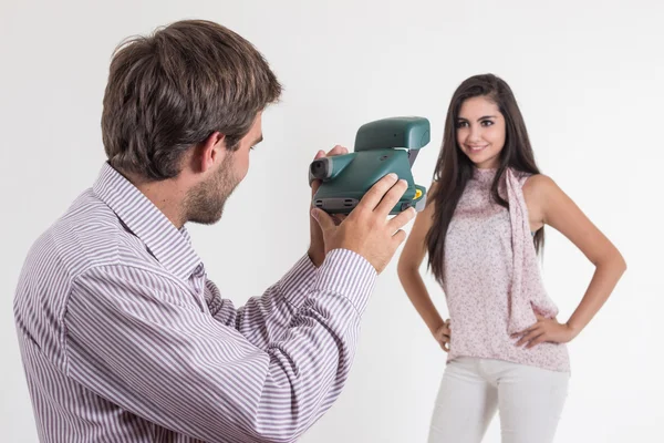 Jovem bonito tirando fotos de menina bonita com câmera instantânea — Fotografia de Stock