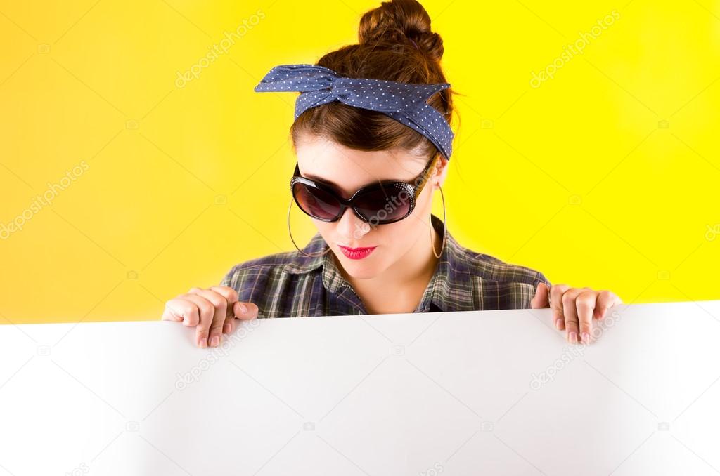 beautiful young retro girl holding white paper over yellow background