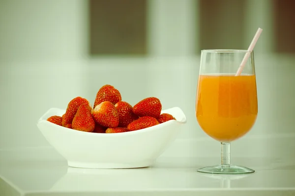 Sumo de morango delicioso em um copo e morangos frescos na tigela — Fotografia de Stock