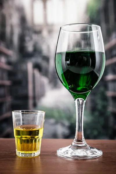 Glas mit grünem Cocktail und gelbem Schuss — Stockfoto