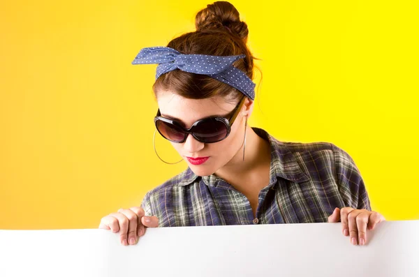 Beautiful young retro girl holding white paper over yellow background — Stock Photo, Image