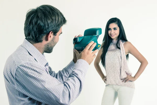 Jovem bonito tirando fotos de menina bonita com câmera instantânea — Fotografia de Stock