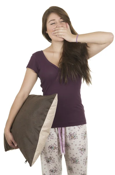 Beautiful young teenage brunette girl in pajamas hugging a pillow — Stock Photo, Image