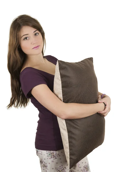 Beautiful young teenage brunette girl in pajamas hugging a pillow Stock Picture