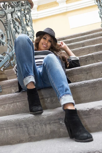 Молодая женщина, сидящая на лестнице — стоковое фото
