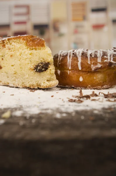 Вкусный кусок домашнего ванильного торта и шоколадный пончик, украшенный кастерным сахаром — стоковое фото