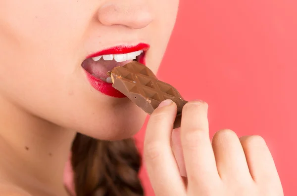 सुंदर युवा लड़की चॉकलेट खाने — स्टॉक फ़ोटो, इमेज