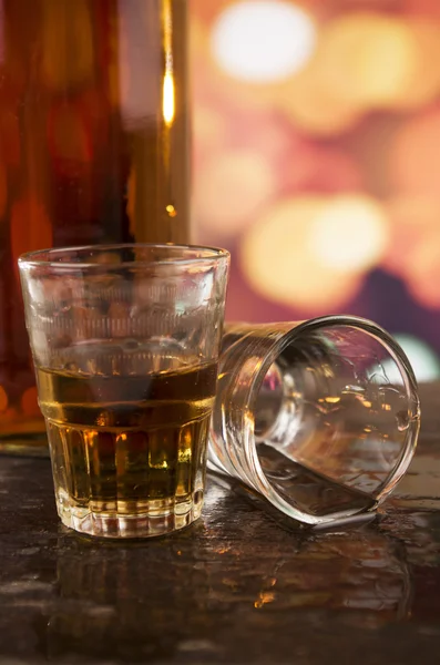 Glas Rum Whisky über defokussiertem Licht Hintergrund — Stockfoto