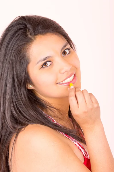 Beautiful young hispanic girl eating candy sweets caramel — Stock Photo, Image