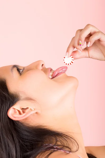 Beautiful young hispanic girl eating candy sweets caramel — Stock Photo, Image