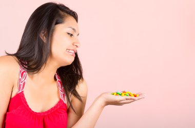 Pretty young teenage girl student looking at candy sweets clipart