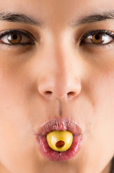 Beautiful young latin woman holding olive in her mouth — Stock Photo, Image