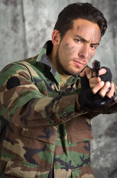 Soldat militanter lateinischer Mann, der eine Waffe zeigt — Stockfoto