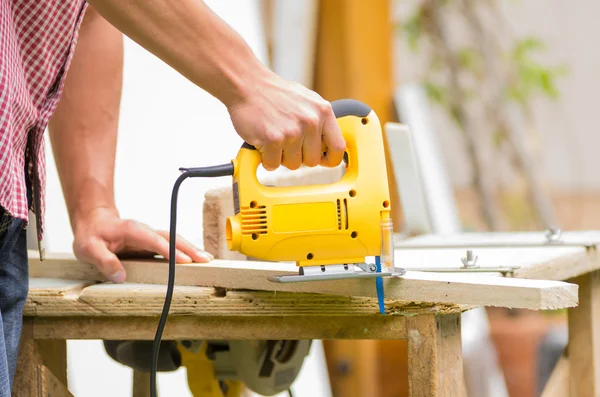 Jeune homme charpentier travaillant avec scie sauteuse électrique et bois — Photo