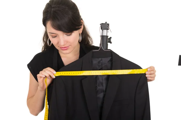 Beautiful young woman tailor measuring a black suit — Stock Photo, Image