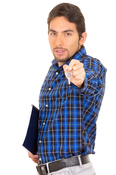 Portrait of handsome hispanic male real estate agent holding a key — Stock Photo, Image