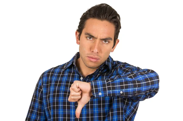 Young angry man wearing a blue plaid shirt posing with thumb down — Stock Photo, Image