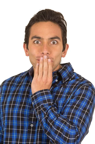 Молодой красивый мужчина в голубой клетчатой рубашке позирует с закрывающим рот ртом — стоковое фото