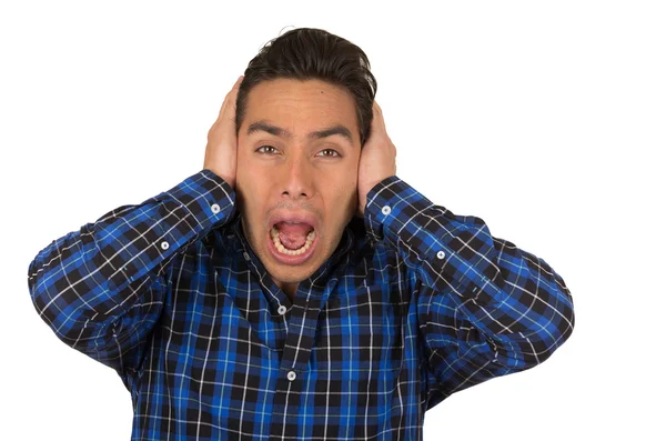 Joven guapo desesperado hombre usando un azul camisa a cuadros posando cubriendo orejas — Foto de Stock