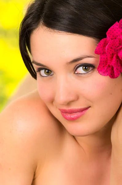 Close-up de bela jovem com flor na cabeça no spa ao ar livre — Fotografia de Stock