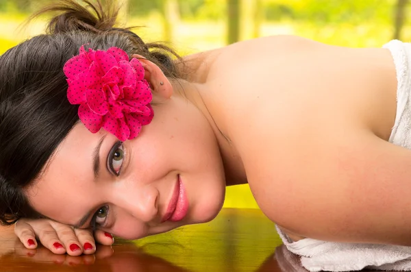 Beautiful brunette woman lying down in outdoor spa — Stock Photo, Image