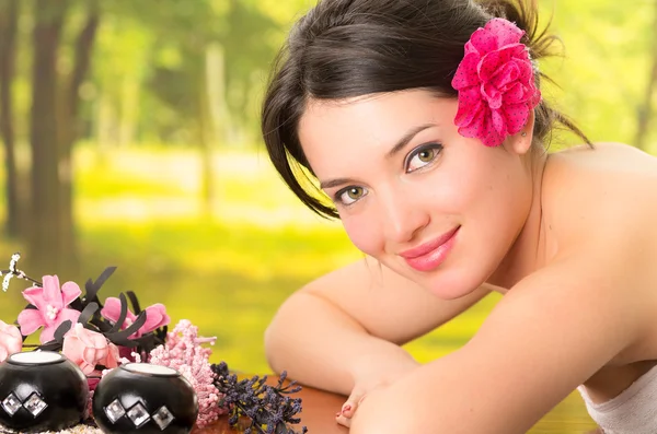 Beautiful brunette woman lying down in outdoor spa — Stock Photo, Image