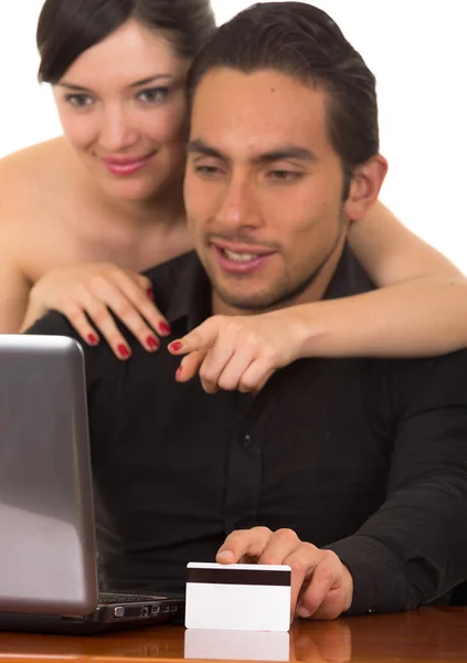 Unga attraktiva lyckliga paret framför datorn köper online med kreditkort — Stockfoto