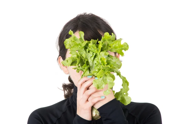 Closeup portrait young girl holding fresh lettuce leaves in front of her face — Stock Photo, Image