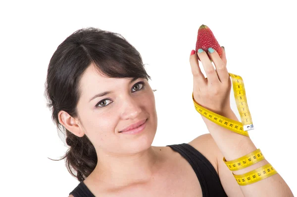 Pretty smiling young woman holding measuring tape ready to enjoy eat strawberry — Stock Photo, Image