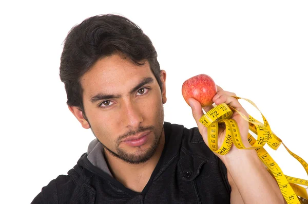 Guapo joven fuerte hombre sosteniendo manzana roja y cinta métrica —  Fotos de Stock