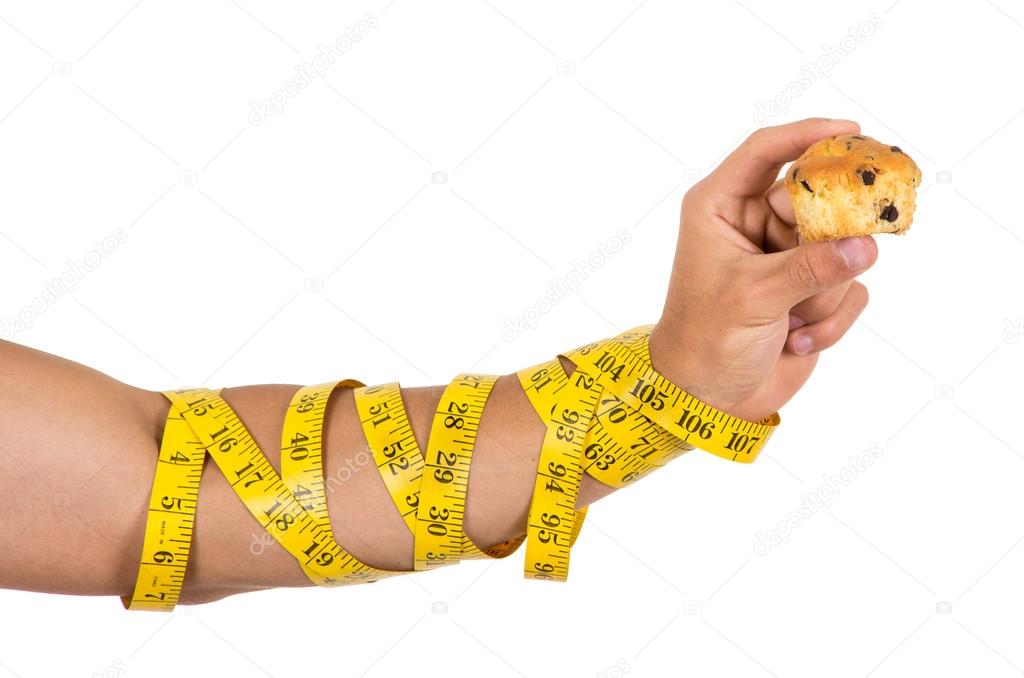 mans arm wrapped in measuring tape holding muffin