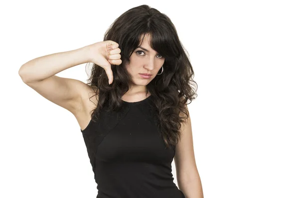 Beautiful young brunette woman with black top posing holding thumb down — Stock Photo, Image