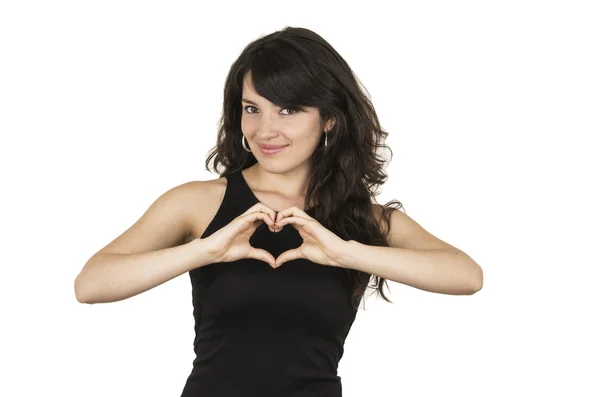 Beautiful young brunette woman wearing black top posing making a heart with hands — Stock Photo, Image