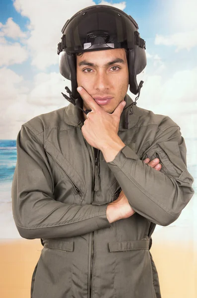 Junge hübsche Pilot trägt Uniform und Helm über Strand Hintergrund — Stockfoto