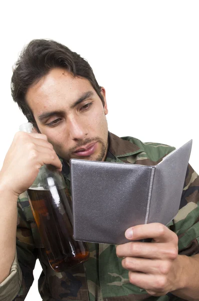 Soldado militar angustiado veterano sosteniendo una botella y mirando fotos ptsd —  Fotos de Stock